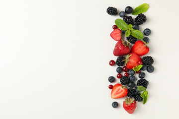 Naklejka na ściany i meble Fresh berries with mint leaves on white background, top view