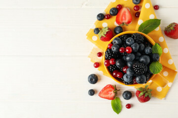 Naklejka na ściany i meble Composition with cup of fresh berries on wooden background, top view