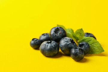 Delicious fresh blueberry on yellow background, space for text