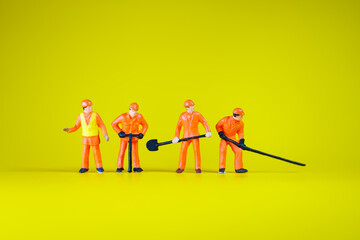 Miniature people, variety engineer team working action using as industry and business concept - Yellow background