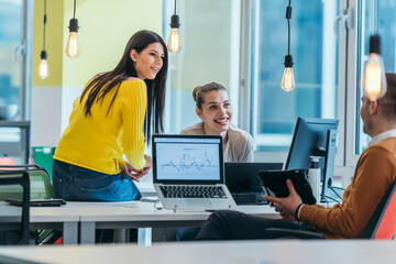 Group of professional coworkers ( team ) working on a desk in a modern office on their laptops...