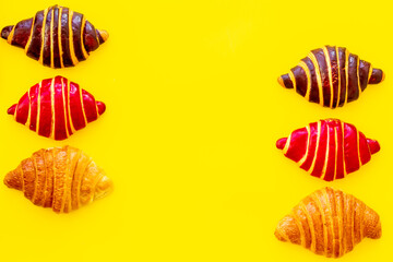 Frame of croissants - fresh bakery on yellow background. Top view