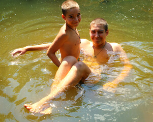 Children play in the water. The brothers play in the river in summer.
