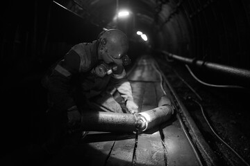Silhouette of a working miner in a mine