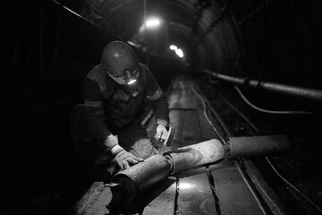 Fototapeta na wymiar Silhouette of a working miner in a mine