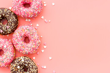 Colorful donuts pink and chocolate icing. Flat lay of bakery, above view