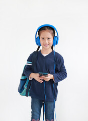 Portrait happy asian little child girl enjoy with smartphone and headphones isolated on white background.