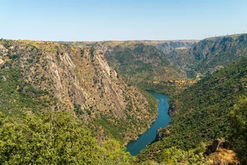 Selbstklebende Fototapeten The river Duero and the high rocky mountains of the Arribes del Duero with the hydroelectric power station at the top being a tourist area in Spain © Chemari