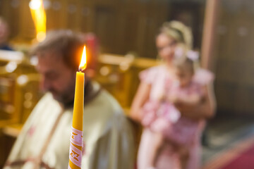 Burning candle at Orthodox christening with blurred background