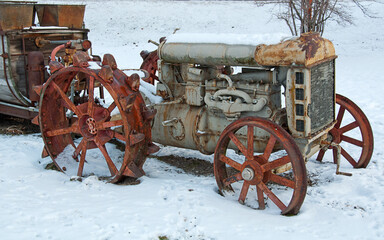 Rusty antique farm tractor in snow