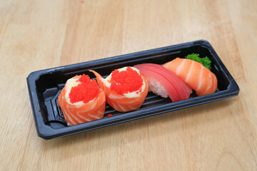 Sushi seafood set on black tray on wood table. Japanese food cuisine