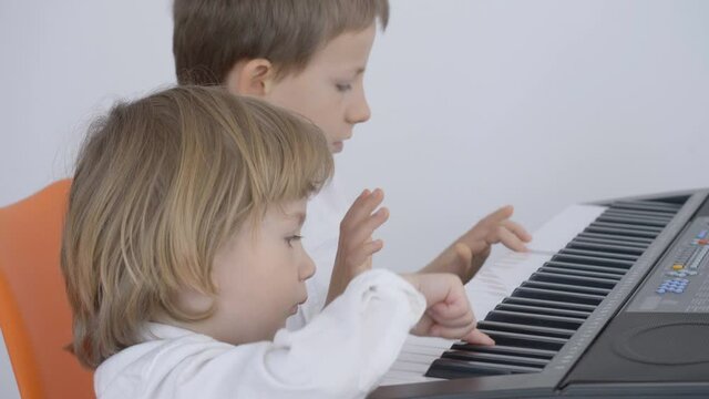 Children play together at piano prepare for performance, teamwork