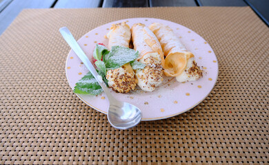 Cannoli Siciliani - traditional dessert stuffed with ricotta cream and nuts with raspberry and mint leaves