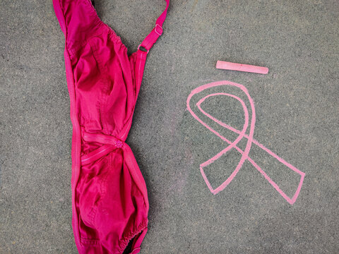 Chalk drawing of Breast Cancer Awareness Ribbon and bra on grey background - Powered by Adobe