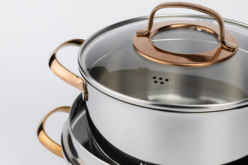 Set of new metal saucepans isolated on white