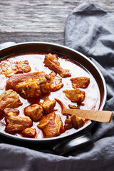 Braised Pork pieces in a black dutch oven