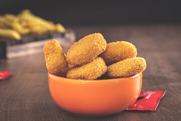 portion of chicken nuggets for home delivery in an orange jar with a black background