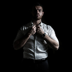 Fototapeta na wymiar Business portrait of a young caucasian man in a white shirt on a black background. 