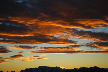 Dramatic sky cluds. Orange lenticular cluds. Sunset. South Patagonian sky.