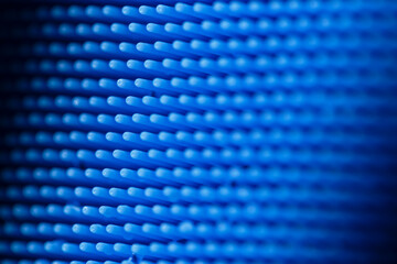 Macro detailed full-frame view of the thin bristles of a blue silicone dish scrubber, for scrubbing...
