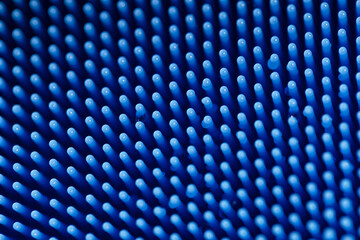 Macro detailed full-frame view of the thin bristles of a blue silicone dish scrubber, for scrubbing pots and pans