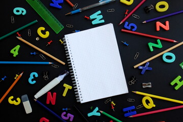 A sheet of squared notebook surrounded by English letters and stationery