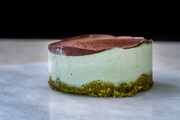 Vegan Raw Round Cheesecake with Mint, Bitter Chocolate and Pistachio Nut Paste.