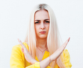 Young woman gesturing stop or saying no, cross her arms isolated on white background. stop violence...