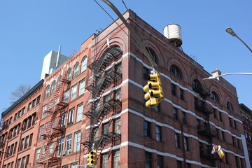 Brownstone windows with fire escape and traffic light 