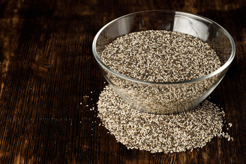 Glass bowl with chia seeds on wooden table