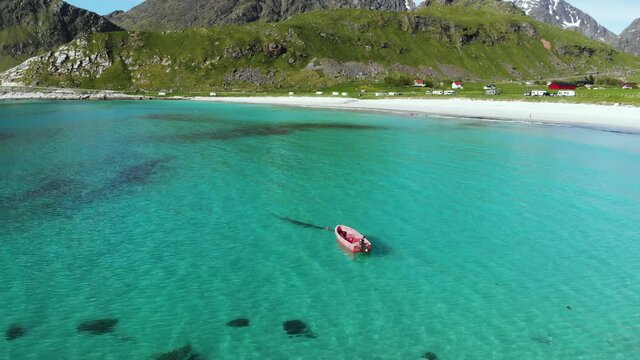 Red boat hovering over turquoise  Water in Lofoten Norway