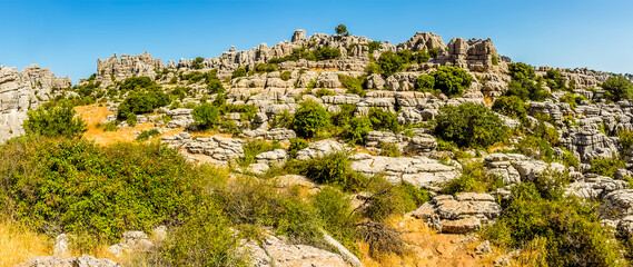 A panorama of the weathered limestone cliff face in the Karst landscape of El Torcal near to Antequera, Spain in the summertime