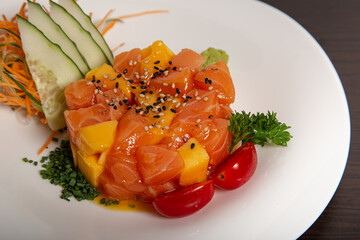 Obraz na płótnie Canvas Healthy plate of tropical fruits and salmon. Tropical tartar. Isolated image.