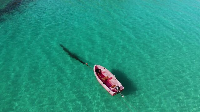Red boat hovering over turquoise  Water in Lofoten Norway