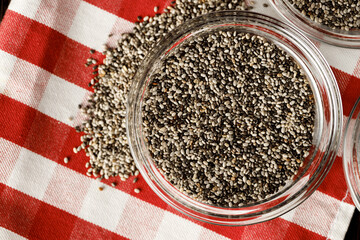 Glass bowl with chia seeds on wooden table