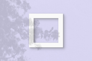 The square sheet of white textured paper on the lilac wall background. Mockup with an overlay of plant shadows. Natural light casts shadows from the leaves of an exotic plant. Flat lay, top view