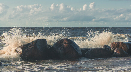 Row of stones with waves splashing over them.