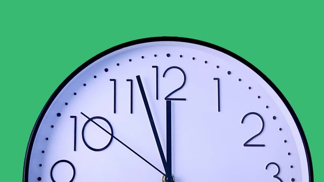 Time-lapse. Have lunch break. Clock display moving showing time almost 12.00 am on large analog clock face. Close-up studio shot on green background. Lunch time, rest, punctuality concept.