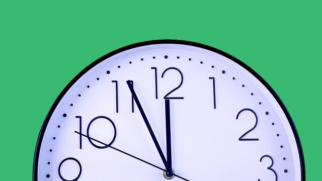 Time-lapse. Have lunch break. Clock display moving showing time almost 12.00 am on large analog clock face. Close-up studio shot on green background. Lunch time, rest, punctuality concept.