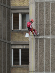 Novi Sad, Serbia, August 5th 2020. - Worker hanging on the rope repairing building facade