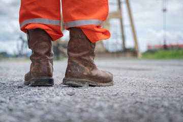 Close-up at Oil field operator's safety boots part with background of outdoor site location....