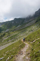 Obraz premium Woman with backpack, hiking in the swiss alps canton of Glarus, Switzerland, vertical