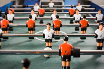 Indoor foosball table with white team vs. red team. Detail of table soccer attackers and defenders