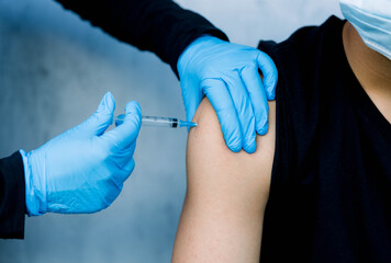 doctor holding syringe, young man getting injection , close up vaccination 