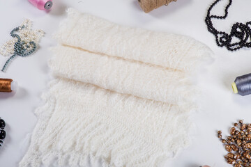 top view folded handmade white woolen scarf with beauty accessories
