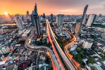 Sunrise over Trident road at Sathorn, Taksin bridge and illuminated traffic at Bangkok - obrazy, fototapety, plakaty