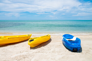 Colorful Kayak boat on tropical beach seaside with blue sky and cloud. Sport, recreation for tourist during holiday vacation. 