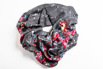 flat lay top view on crumpled grey silk scarf with bright roses floral ornament