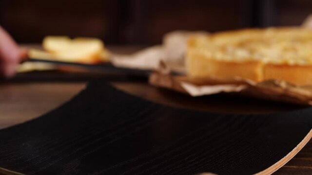 Anonymous person using knife to take slice of apple pie from parchment and putting dessert on plate