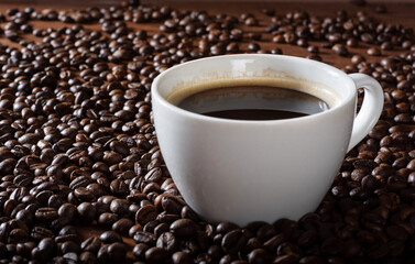 Espresso coffee on the table with coffee beans. Scattered coffee beans on a wooden table.